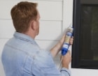 person applying sealant to a doorframe