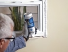 man applying sealant to chimney flashing