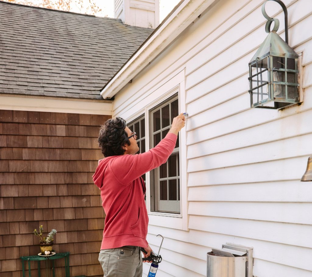 A homeowner removes old sealant with GE’s Sealant Remover Tool.