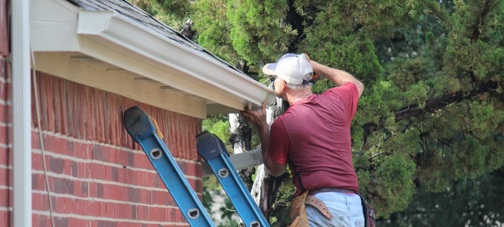 A person repairing gutters