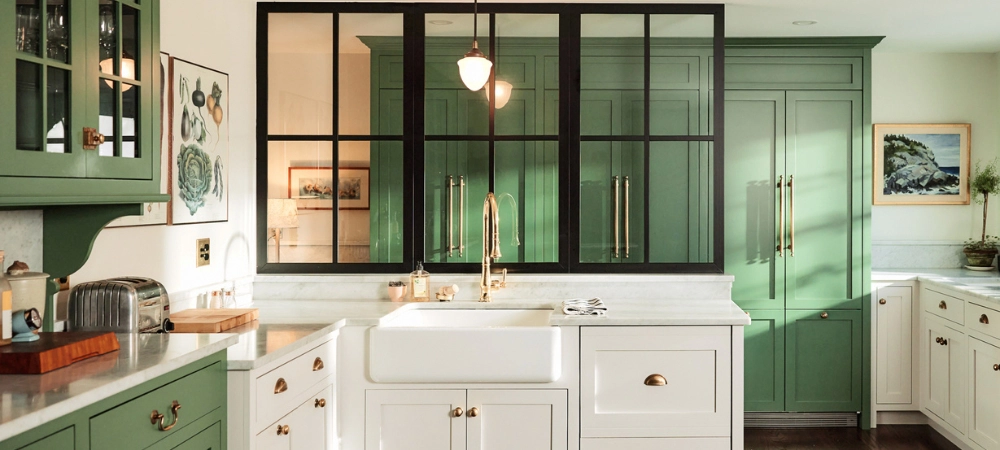 A modern kitchen with green cabinets, white countertops, and a farmhouse sink, showing the clean results of a weekend kitchen refresh.
