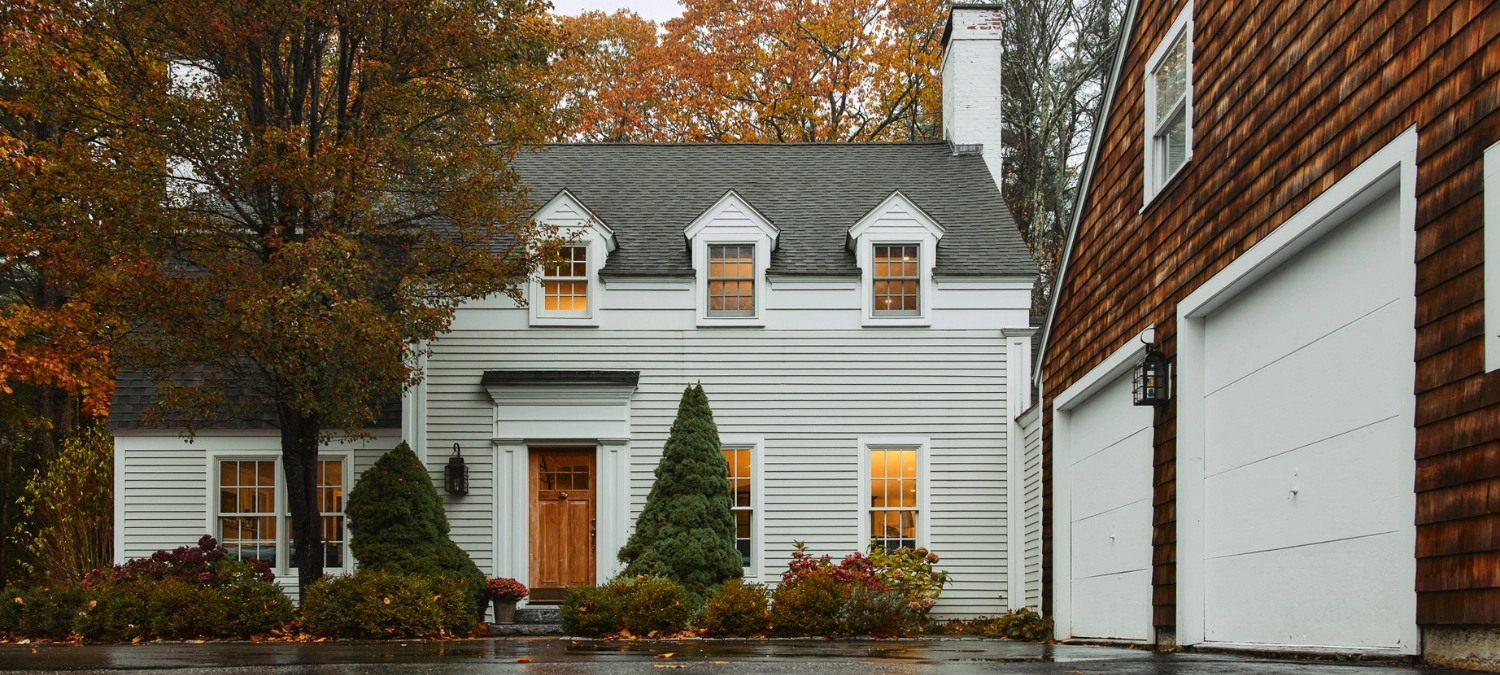A weather-sealed home exterior with visible trim and siding, captured during fall after rainfall—showing the result of seasonal weatherproofing.