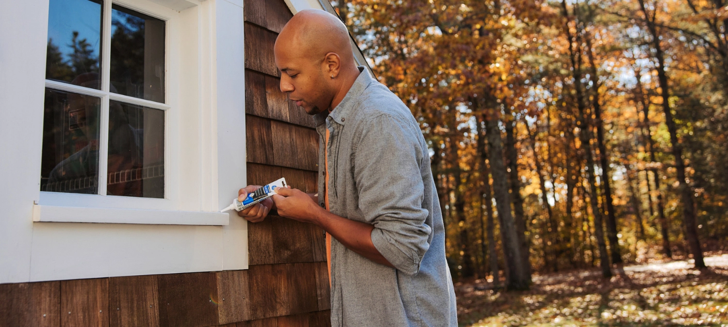 Applying GE Supreme Silicone Window & Door to exterior trim for long-lasting weather protection.