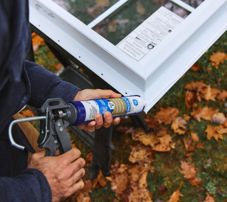 Applying silicone sealant in wet weather.