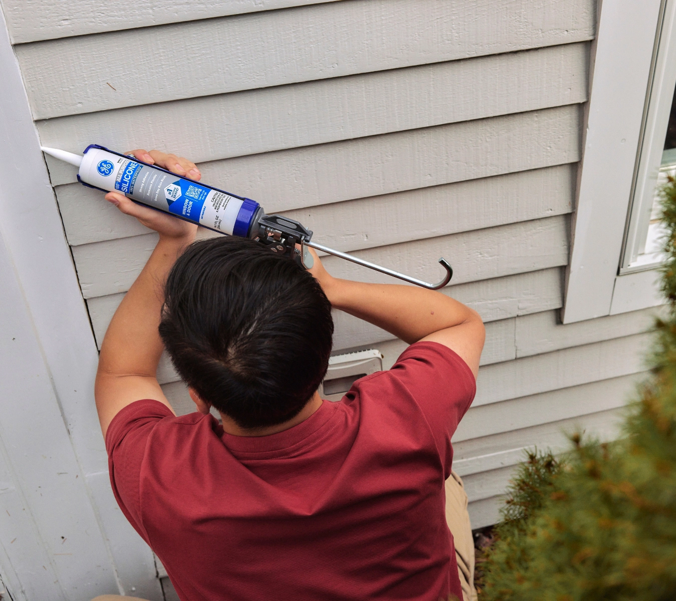 Sealing gaps around an exterior door frame with silicone to block air, moisture, and pests.