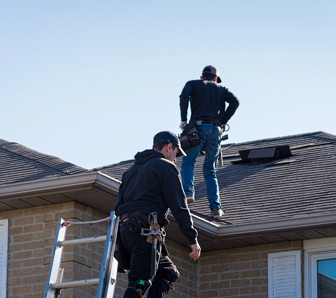 A person inspecting flashing around a roof vent while preparing to seal leak-prone areas.