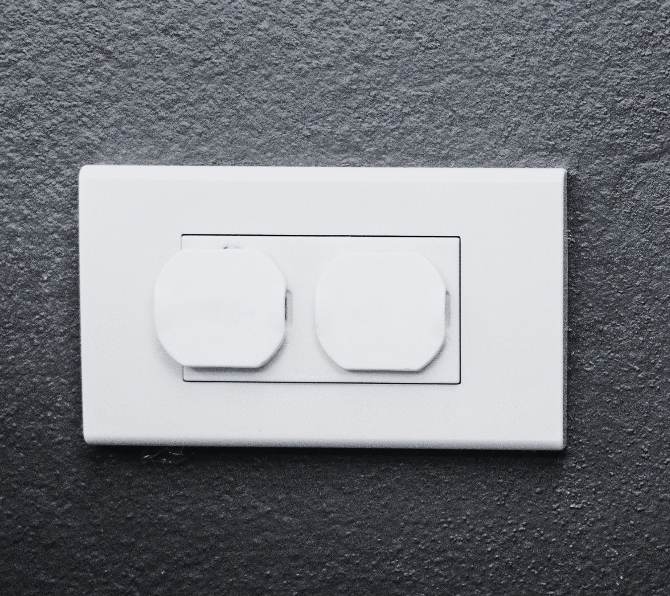Child-proof safety plug placed inside an electrical outlet showing how to air-seal electrical outlets.