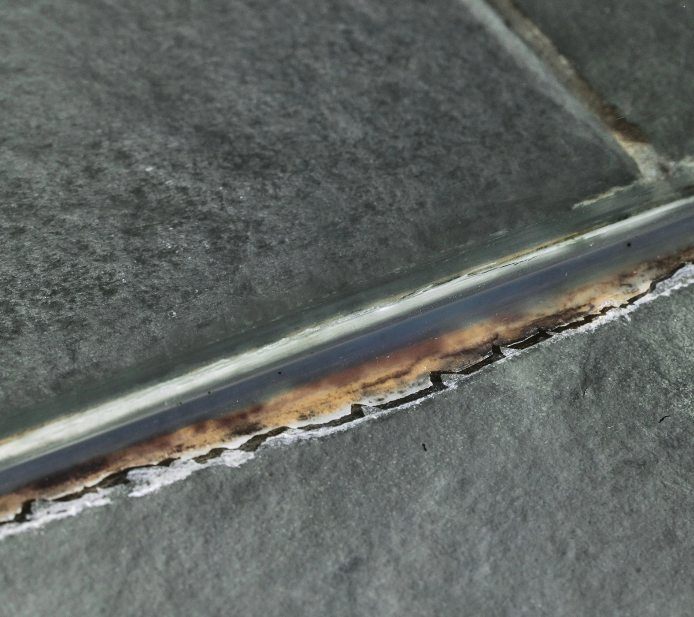 Mold and mildew on silicone sealant around a shower.