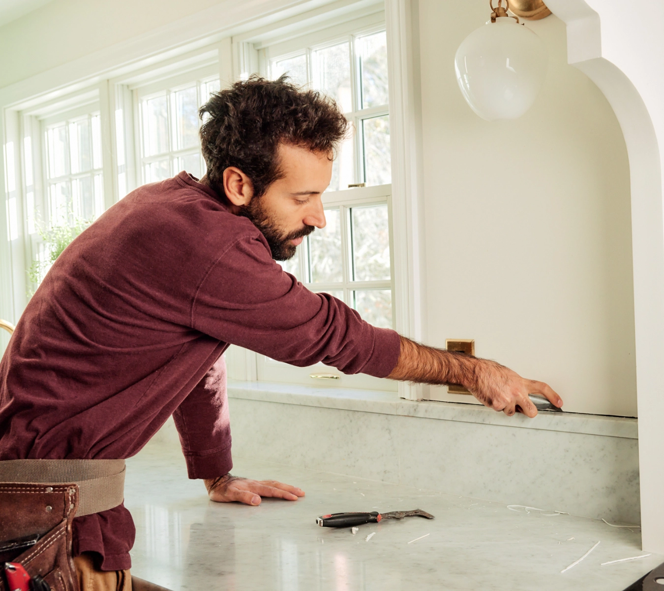A homeowner removes sealant.
