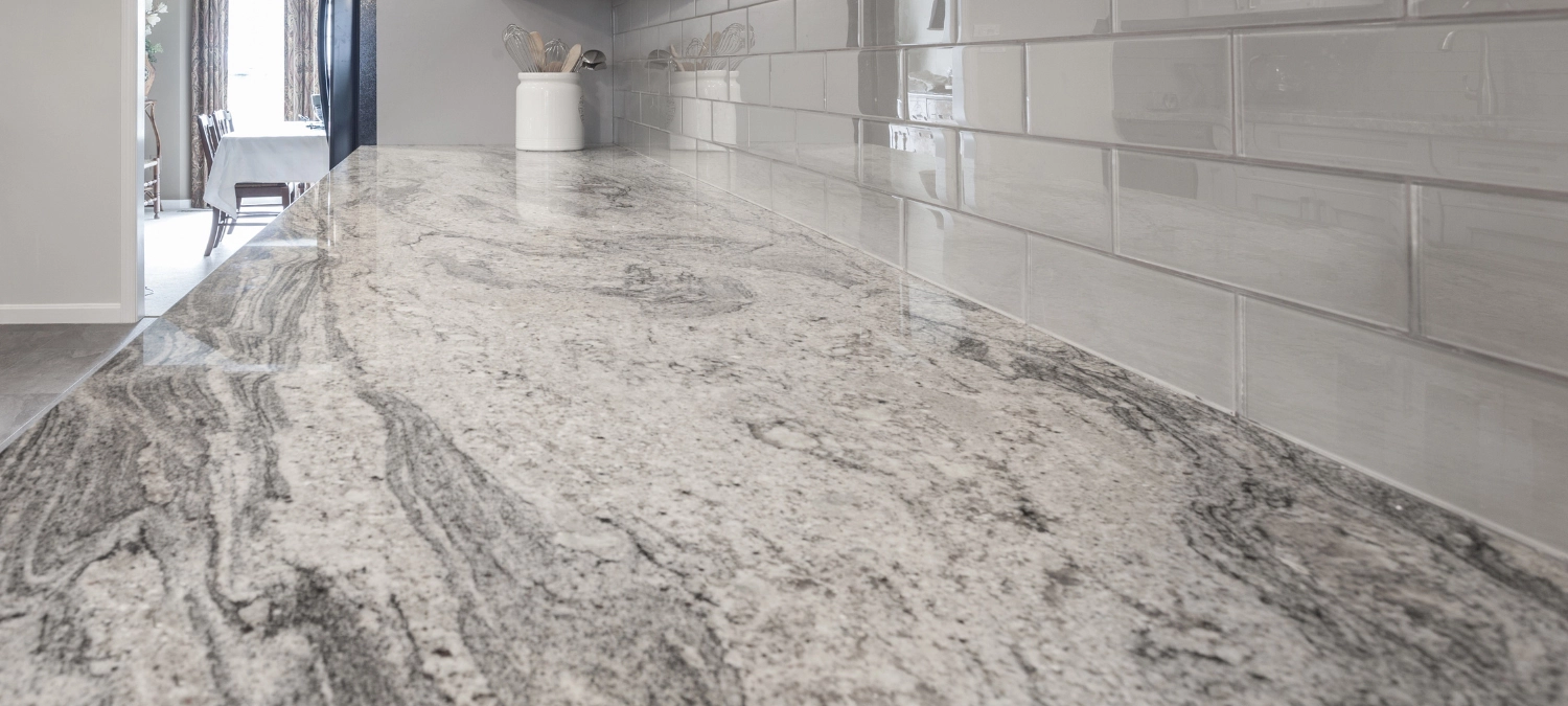 Clean, sealed joint between granite countertop and subway tile backsplash using GE silicone.