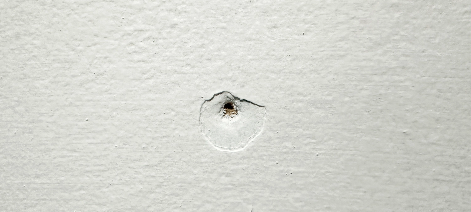 A photo of nail holes in drywall.