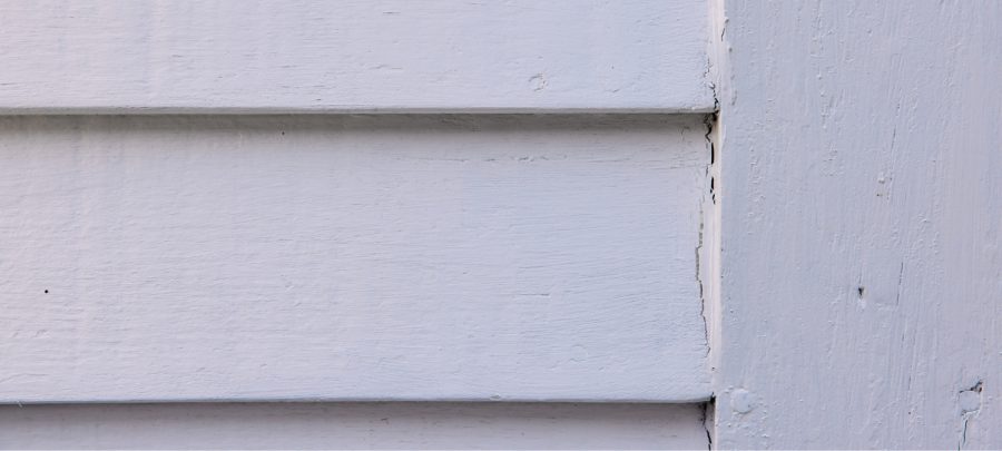 Old, peeling sealant along an exterior window frame.