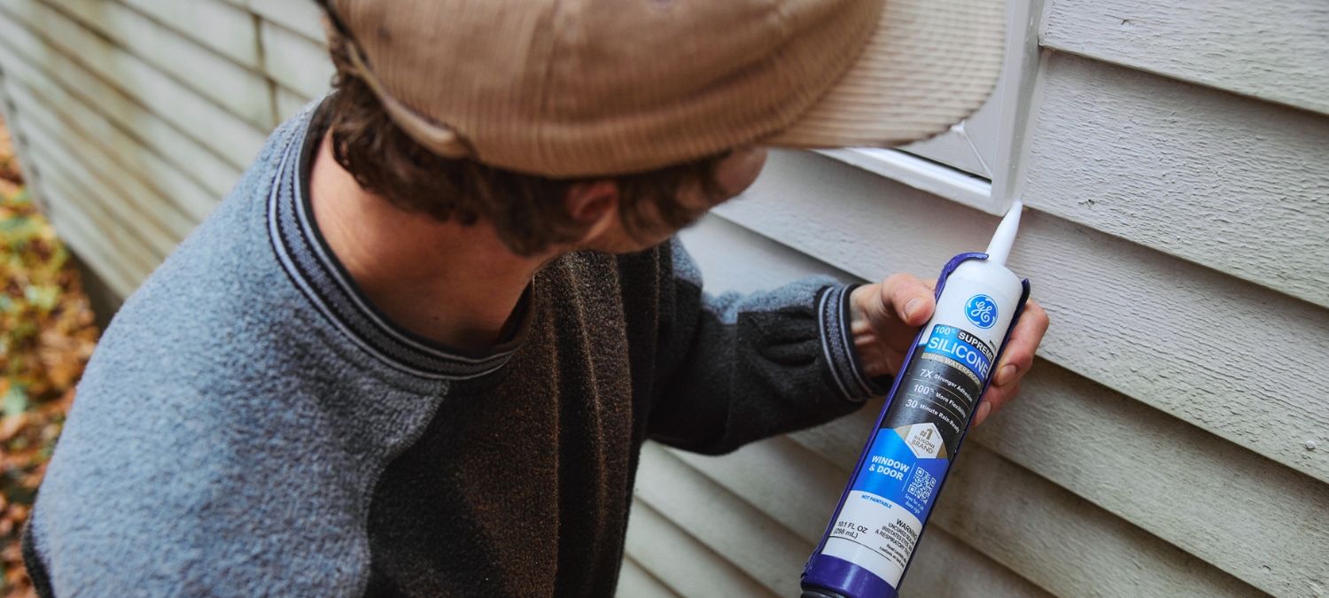 Contractor applying GE Supreme Silicone Window & Door Sealant to exterior siding joint.