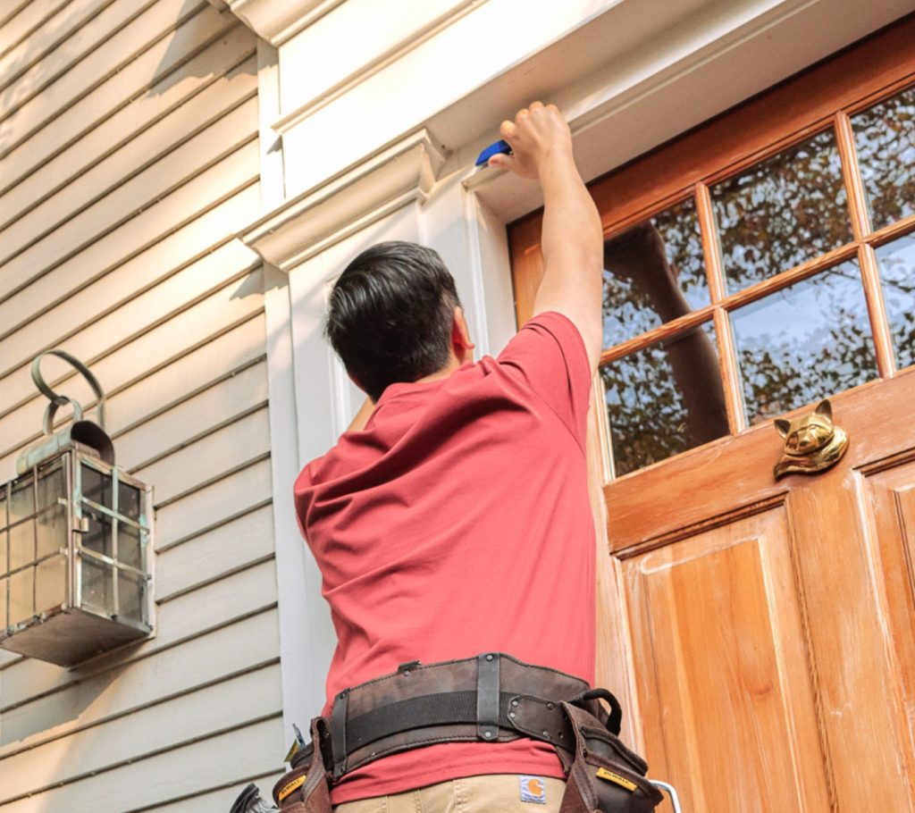 A homeowner smoothing a bead of sealant with GE’s Sealant Smoothing Tool.