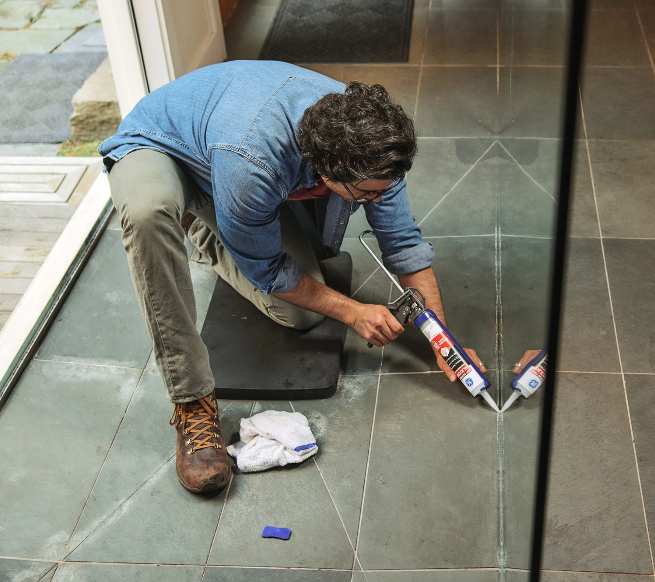 A person applying GE Advanced Silicone Kitchen & Bath Sealant bead with proper trigger pressure for a clean finish.