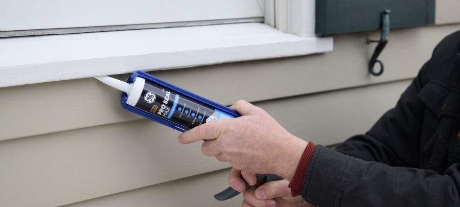 1 A photo of a DIYer sealing a gap in an exterior window seal on a residential home. e1772570163550