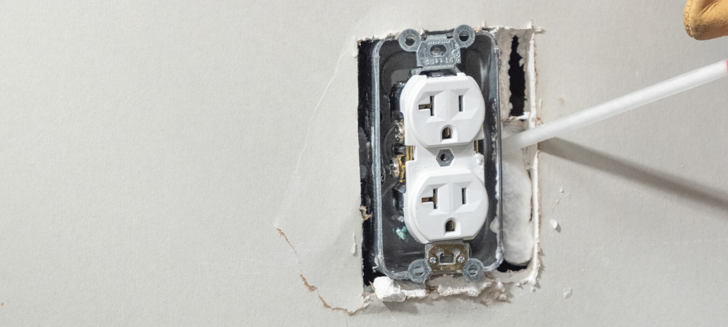 A gap in an electrical outlet filled with insulating foam.