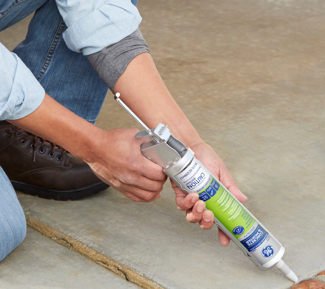 DIYer using GE Concrete Silicone along a garage wall base to create a clean, watertight seal.