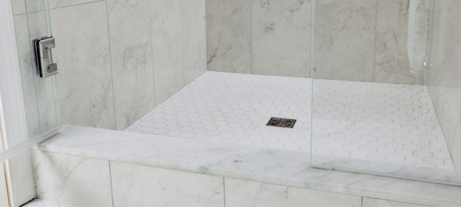 Freshly applied GE silicone sealant forming a clean, watertight joint along bathroom tile edge.