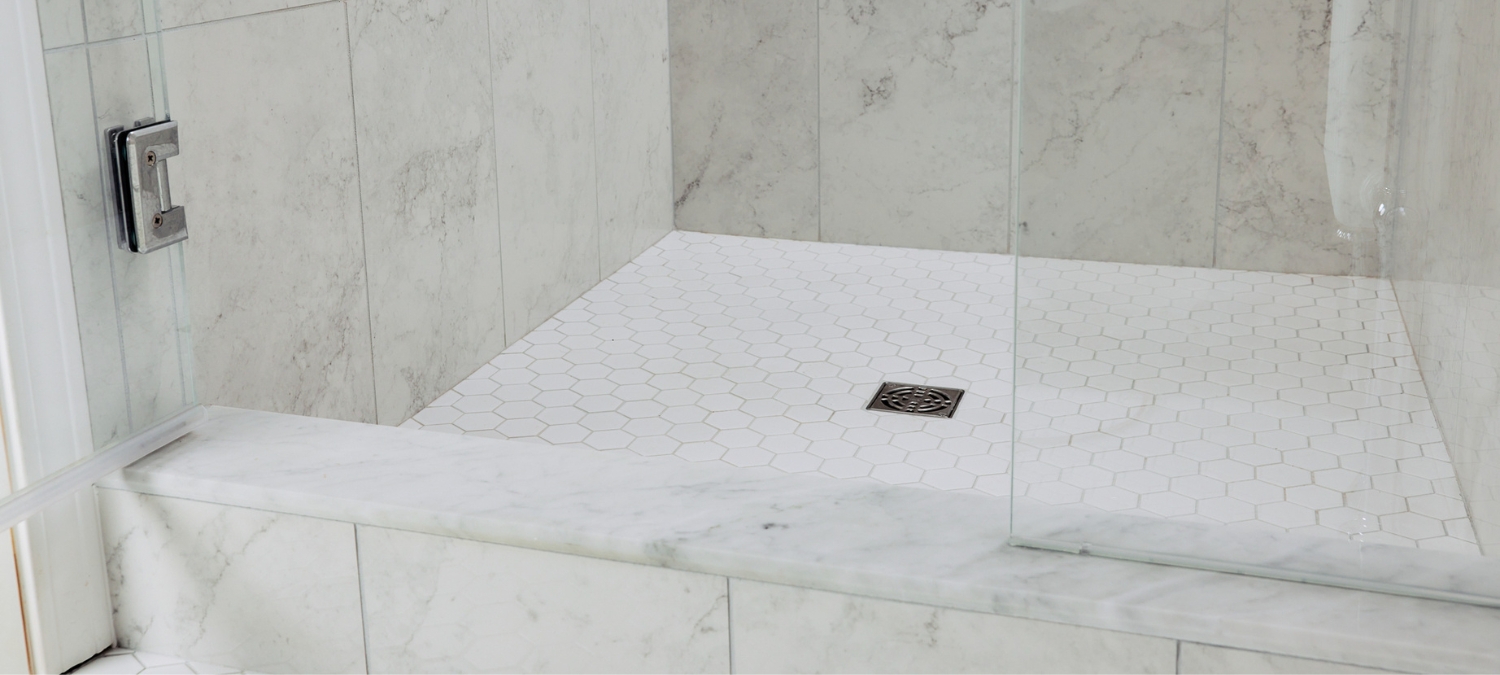 Freshly applied GE silicone sealant forming a clean, watertight joint along bathroom tile edge.