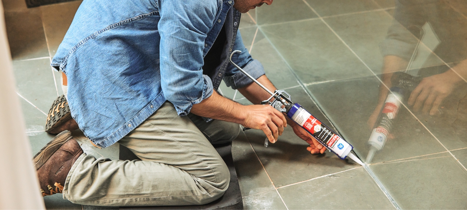 Mold-resistant GE Supreme Silicone Kitchen & Bath silicone sealant bead applied neatly around a tiled shower base.