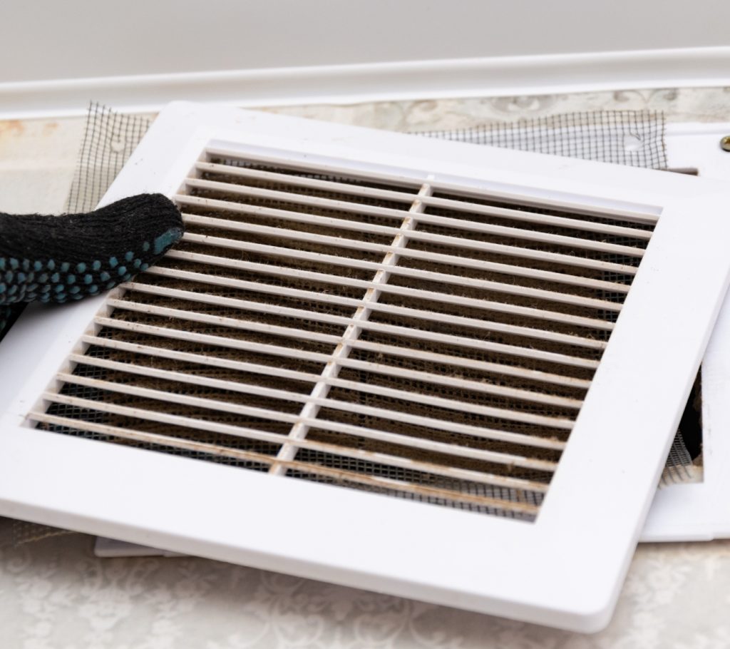 Homeowner replacing a home air filter to improve HVAC efficiency and indoor air quality as part of annual maintenance.