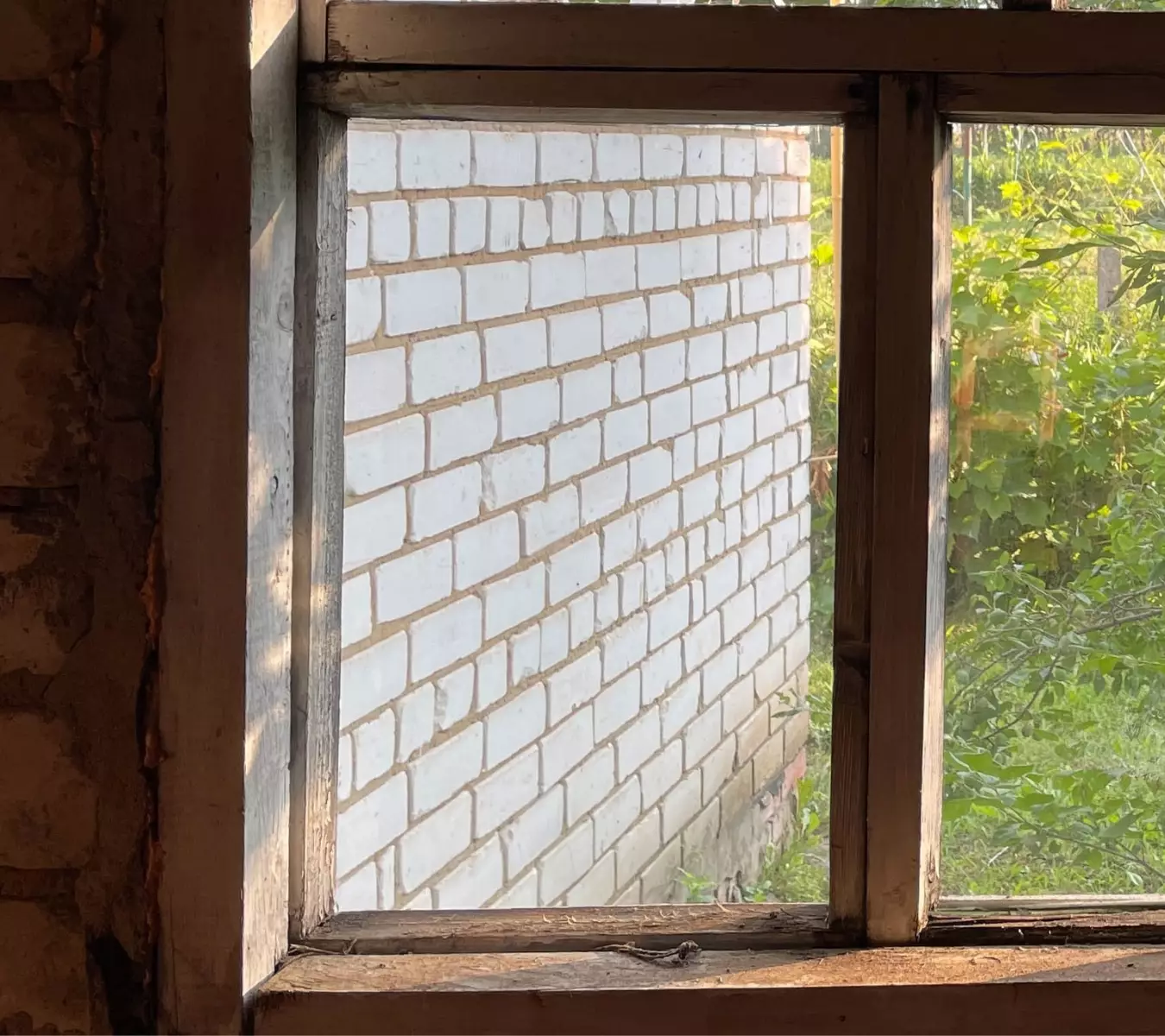 Older window lower corner showing repeated staining and paint failure near sill-adjacent trim.