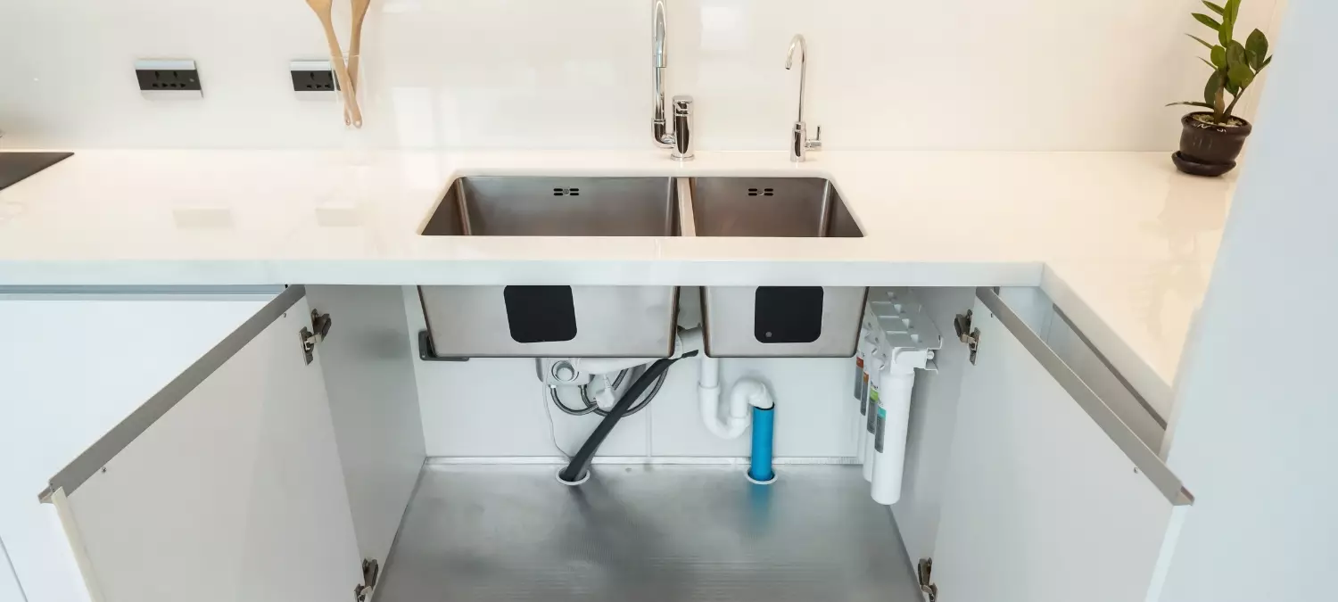 A photo of open cabinets under a kitchen sink