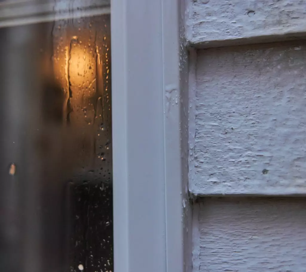 A photo of sealant between a window frame and siding